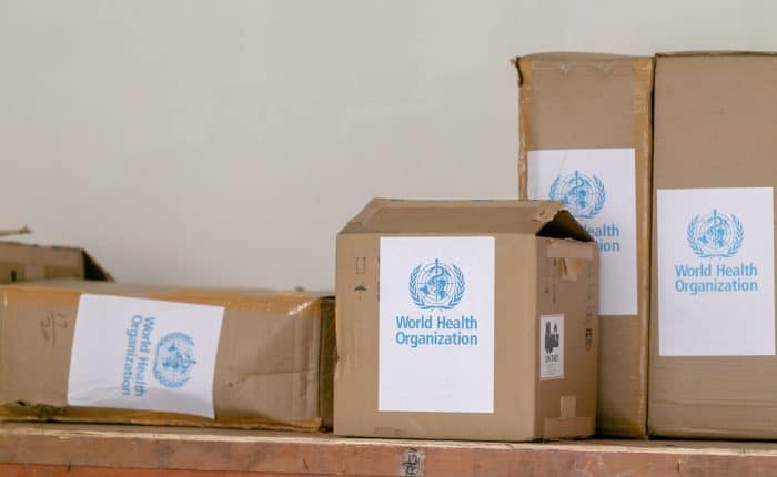 cardboard boxes with world health organisation stickers