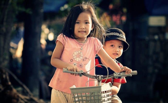 two kids riding a bike