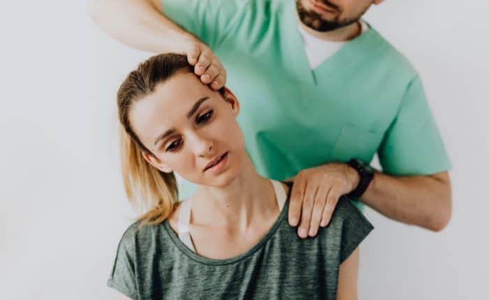 doctor examining a patient by tilting her head