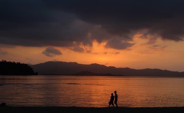 couple walking in the sunset on the beach