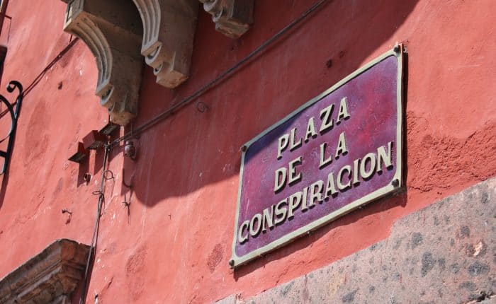 Photo of a building focused on a signage that reads: plaza de la conspiracion