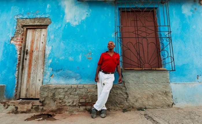 man standing in front of a bright blue building