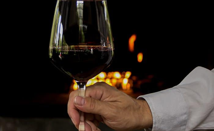 man holding a glass of red wine