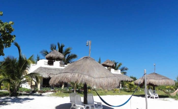 view of two chairs under a large umbrella, with a beautiful blue sky