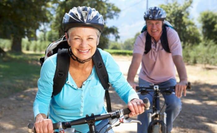 retirees with a smile on their faces, riding their bikes