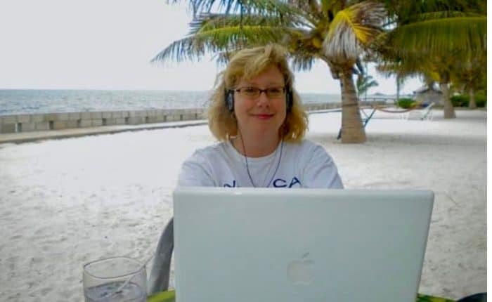 Woman working on the beach with her laptop in Belize
