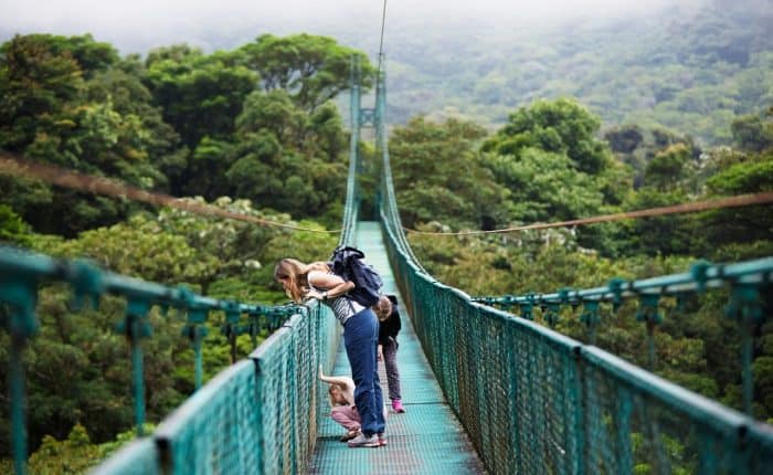 2 girls and a child on a suspension bridge in Costa Rica