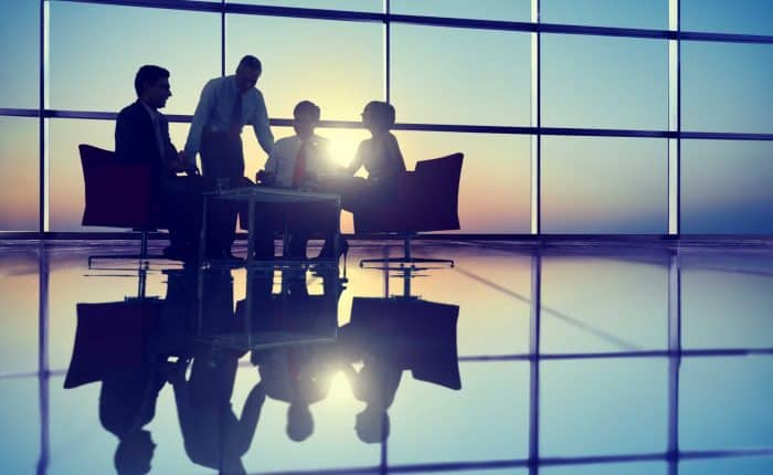 people around a desk with a sun set in the back ground