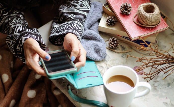 girl on her phone with a cup of coffee