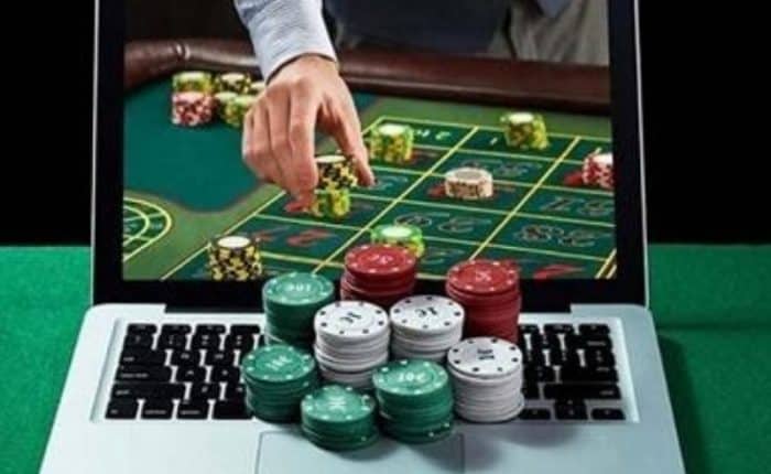 man's hand coming through the computer for casino chips