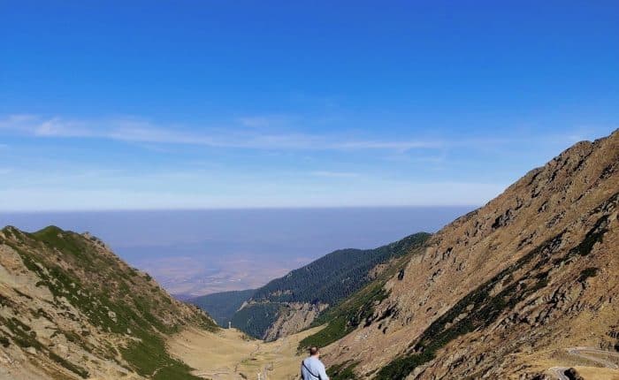 Man in a valley overlooking the mountains